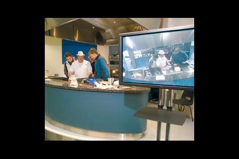 A screen relays the fine detail of food preparation in the catering lecture theatre. The high extract volumes in these areas caused headaches for the designers